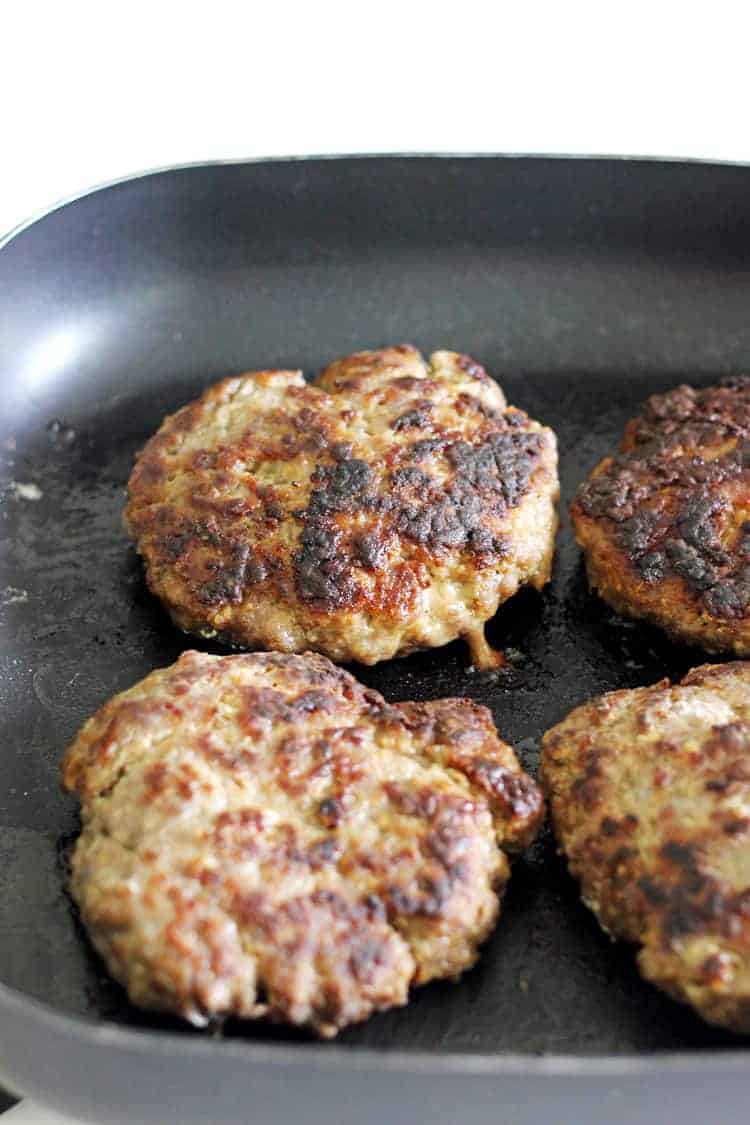 Homemade beef burger patties being cooked