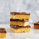 3 pieces of peanut butter bars stacked on a white background