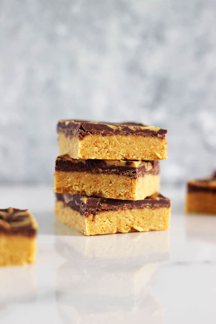 3 pieces of peanut butter bars stacked on a white background