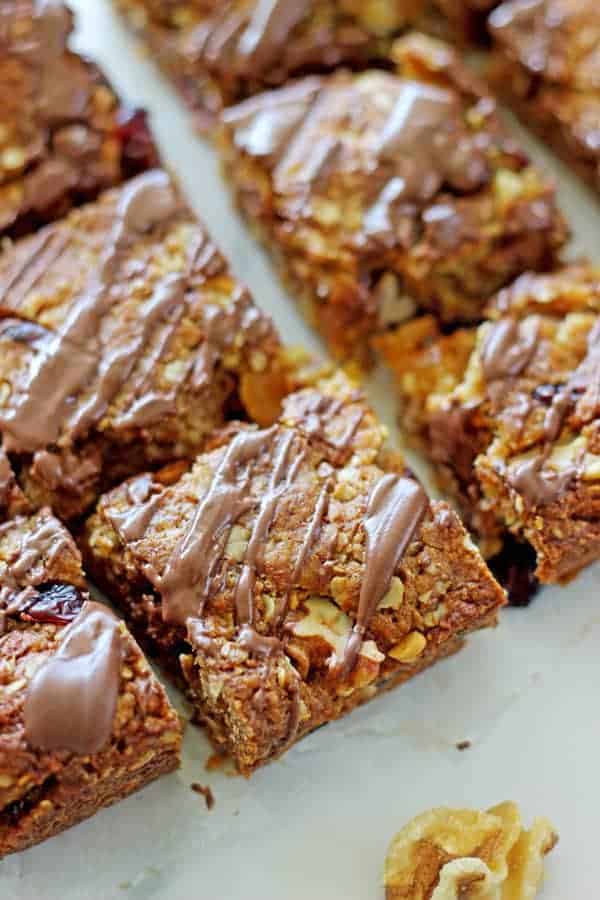 This loaded Anzac slice recipe is a twist on the traditional Anzac biscuits, filled with cranberries, apricot, walnuts and topped with a chocolate drizzle!