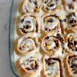 Hot Cross Bun Cinnamon Rolls! The perfect combination of delicious cinnamon rolls with all the spices and dried fruit that you love about hot cross buns! A must have for Easter brunch | thekiwicountrygirl.com