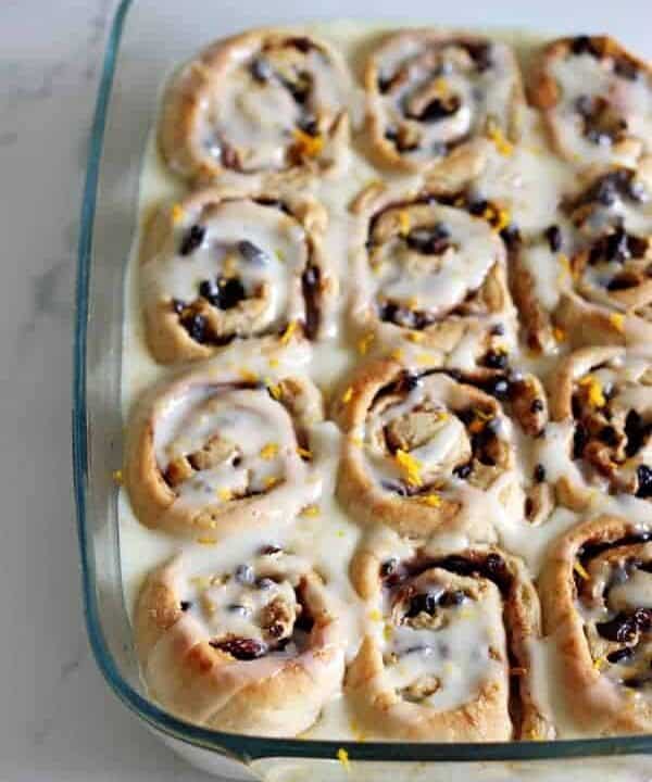 Hot Cross Bun Cinnamon Rolls! The perfect combination of delicious cinnamon rolls with all the spices and dried fruit that you love about hot cross buns! A must have for Easter brunch | thekiwicountrygirl.com