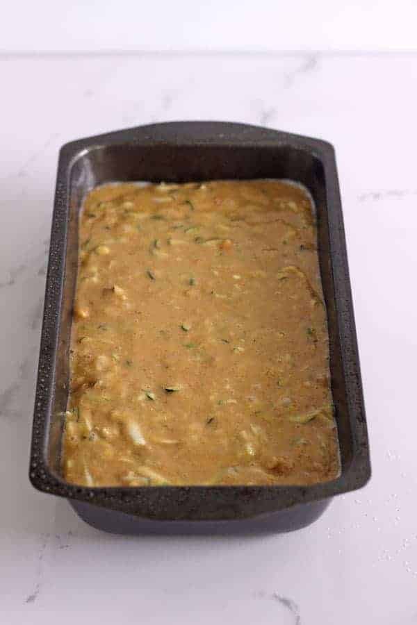 Zucchini bread in loaf tin ready to go in the oven
