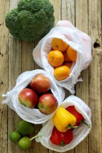 Reusable produce bags with apples mandarins and peppers