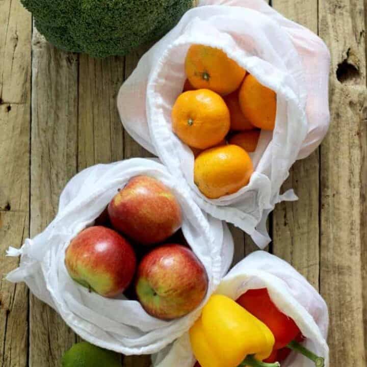 Reusable produce bags with apples mandarins and peppers