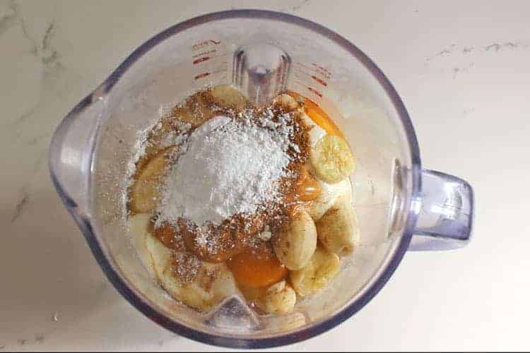 Blender with ingredients for healthy banana oatmeal muffins