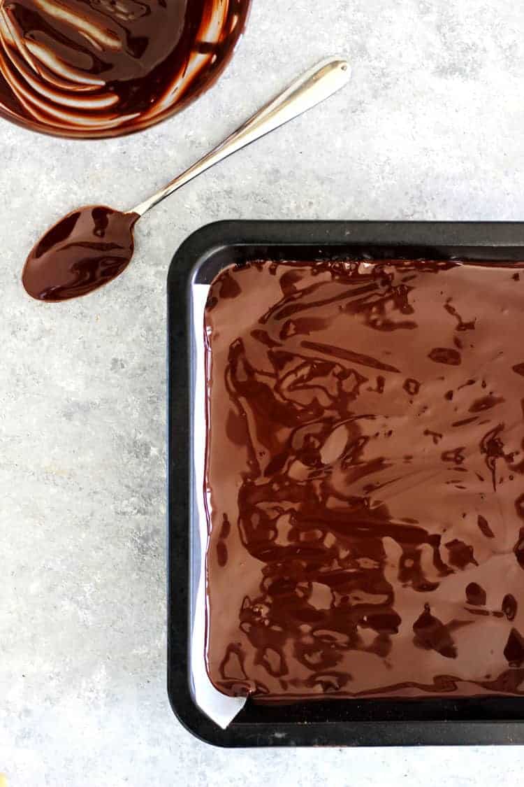 Chocolate slice in tin with spoon covered in chocolate