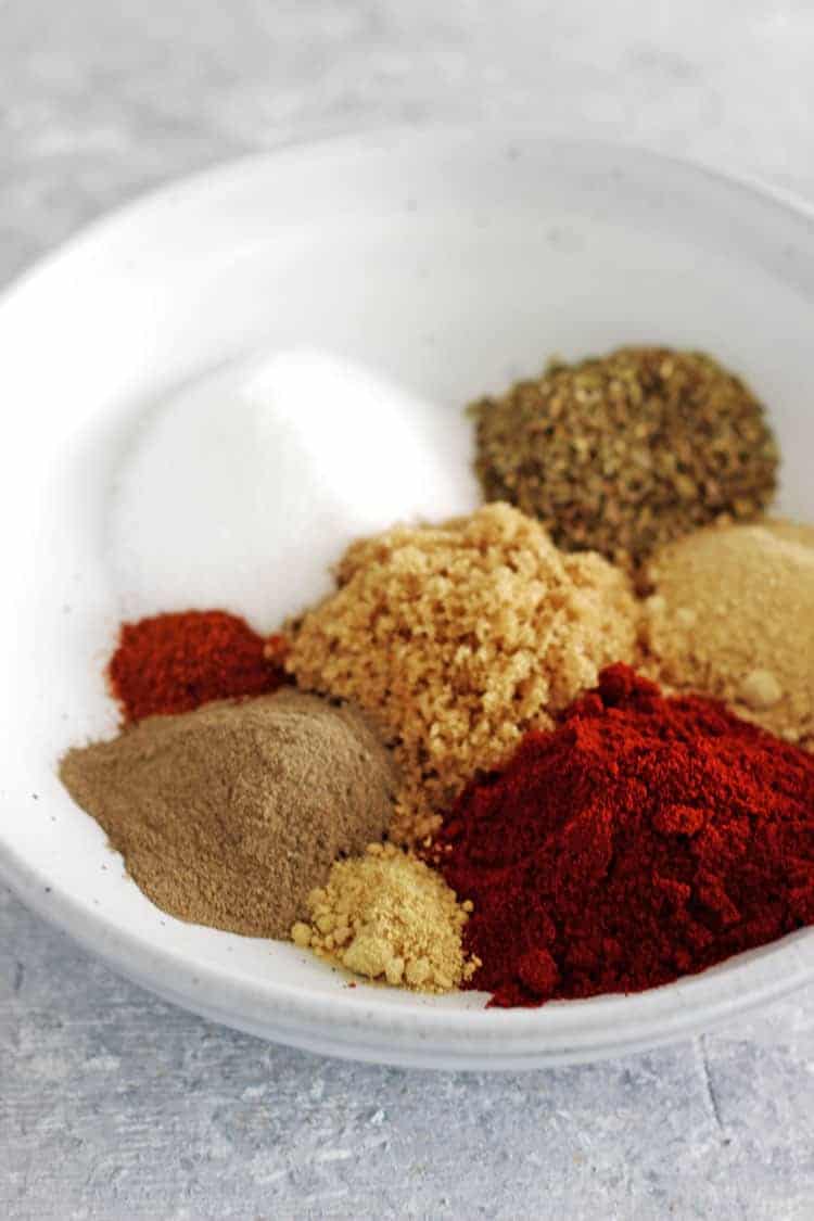 Bowl of spices for bbq spice rub on grey background