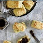 Overhead image of cheese and herb scones with onion chutney and text overlay