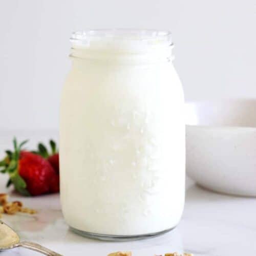 Jar of yoghurt on white background with berries