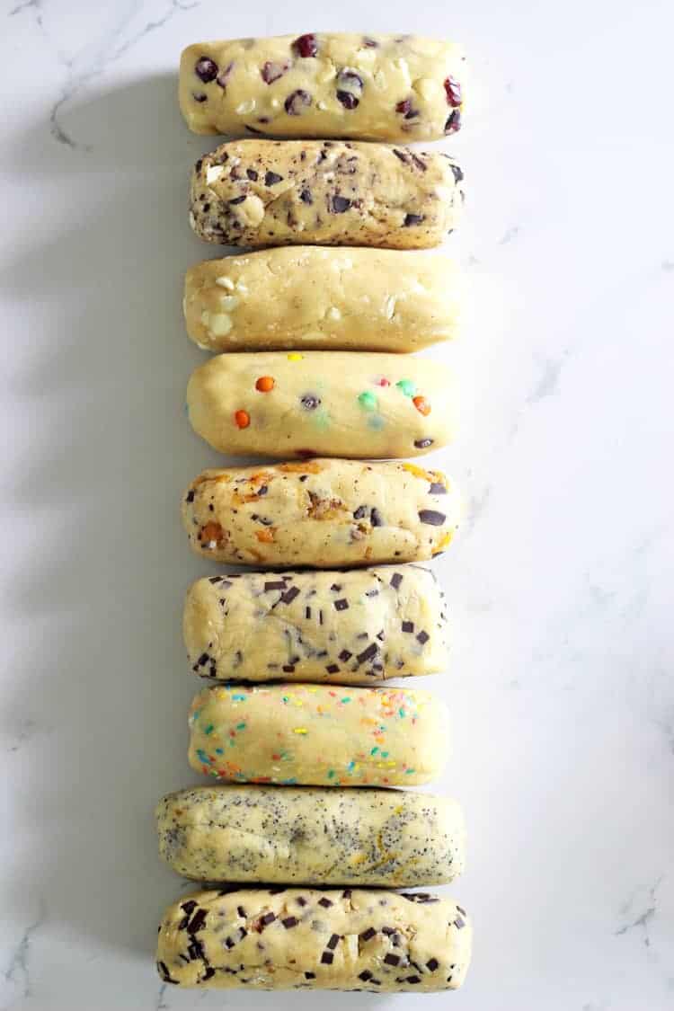 Rolls of slice and bake cookie dough lined up on a white background