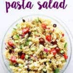 Glass bowl of Greek pasta salad on white background with text overlay