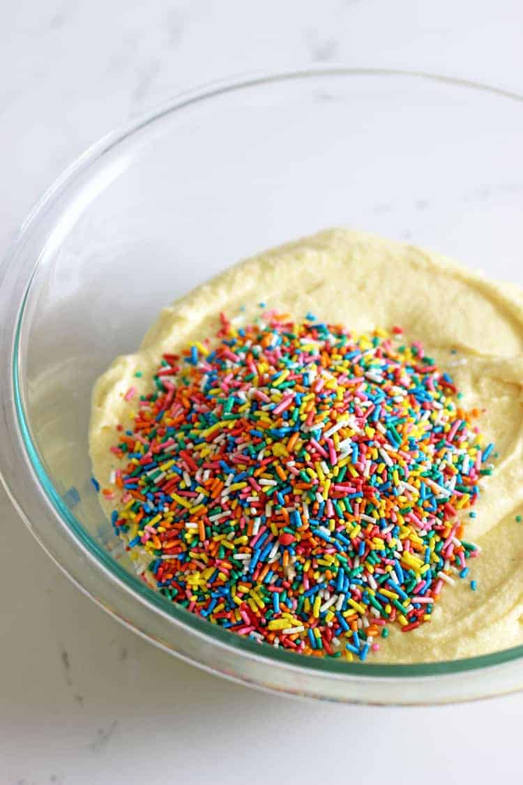 Glass bowl with vanilla cake batter and sprinkles