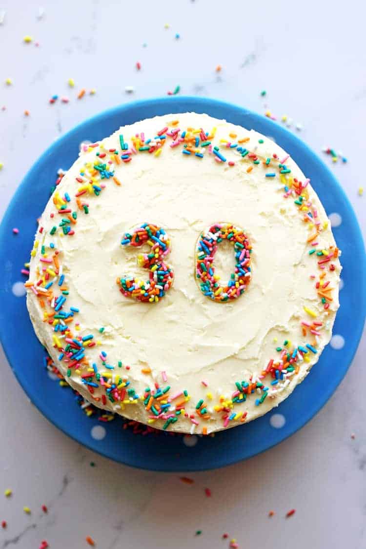 6 inch sprinkles layer cake on a blue plate with a sprinkled 30 on top