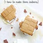 A stack of s'mores on a sheet of baking paper with marshmallows on the side and another s'more with a bite taken out with text overlay
