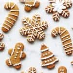 Decorated gingerbread cookies with royal icing in various shapes on a white background