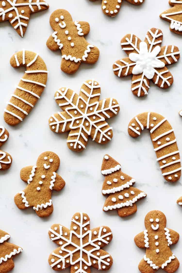 Decorated gingerbread cookies with royal icing in various shapes on a white background