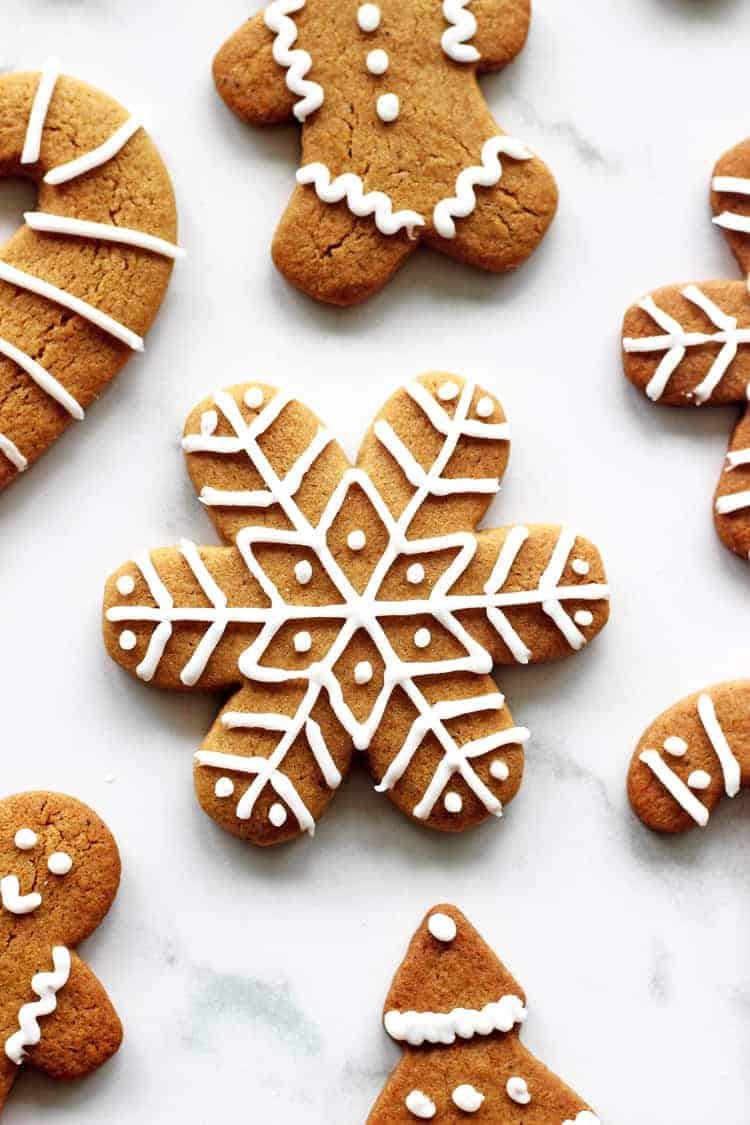 Snowflake shaped decorated gingerbread cookie with royal icing on a white background