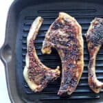 Lamb chops covered in herb marinade in a grill pan