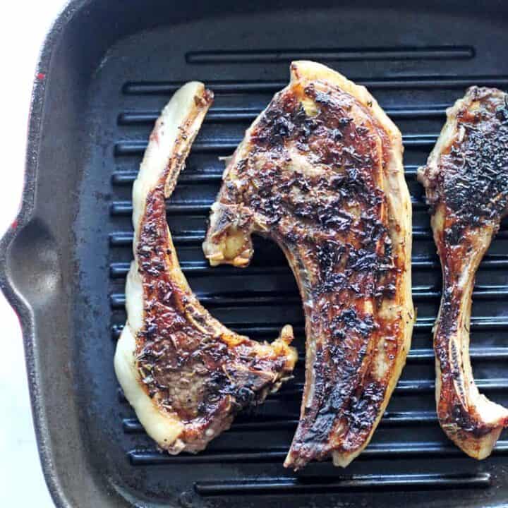 Lamb chops covered in herb marinade in a grill pan