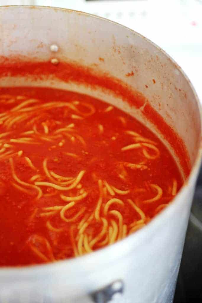 Bottled spaghetti in sauce in a large pot on the stove