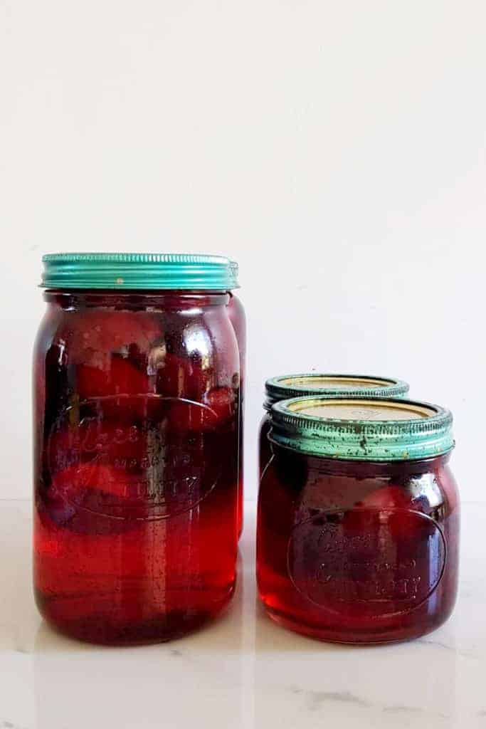 Agee jars with plums and sugar syrup all sealed