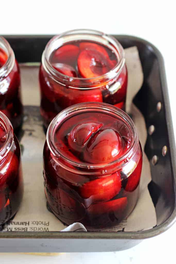 Agee jars with plums and sugar syrup ready to be processed