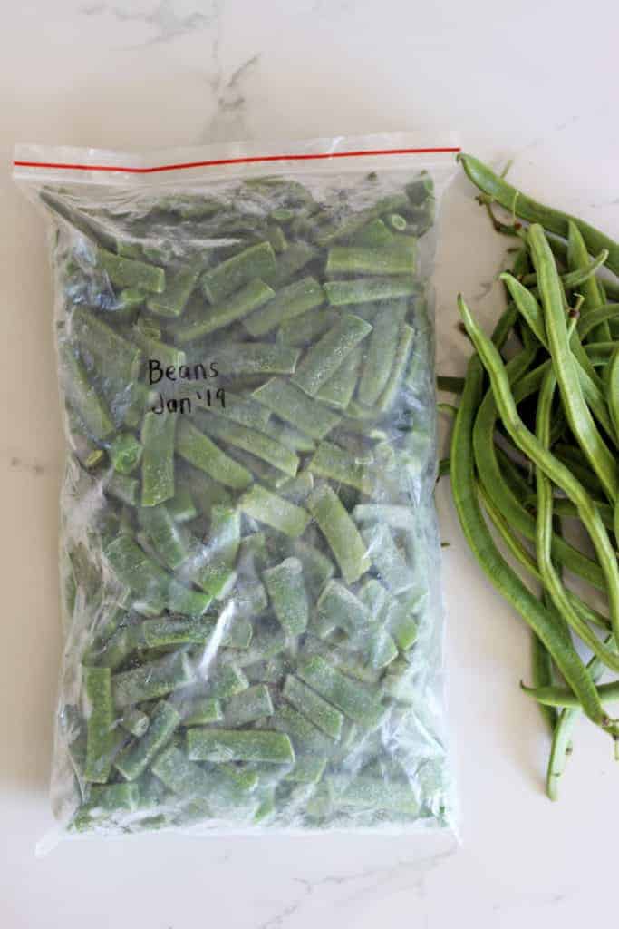 Snaplock bag of frozen green beans with fresh green beans alongside