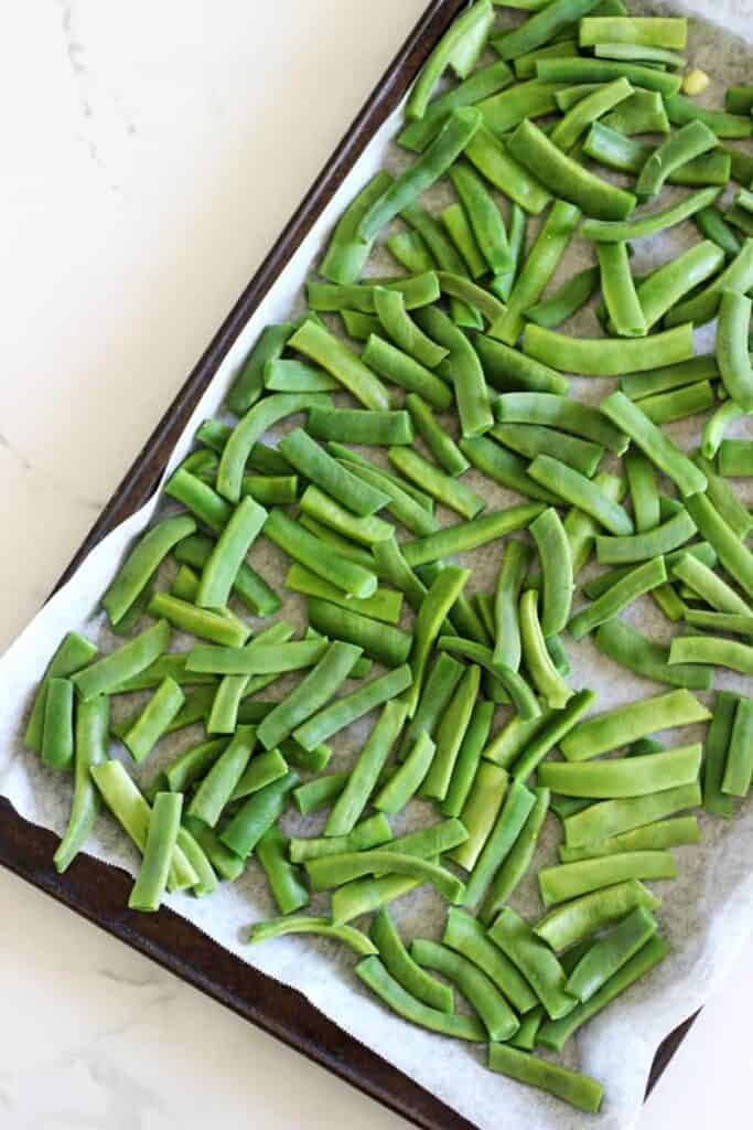 Tray of green beans on a white background