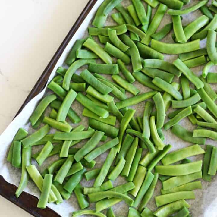 Tray of green beans on a white background