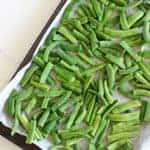 Tray of green beans on a white background with text overlay