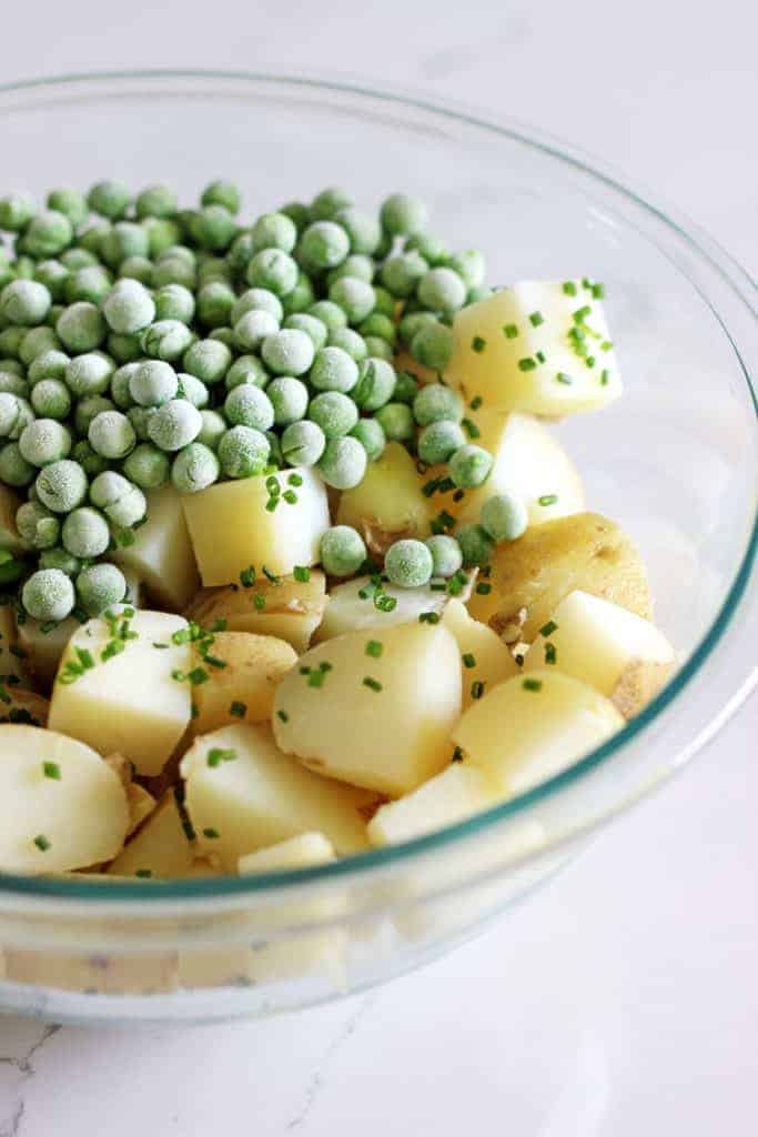 Bowl with chopped potatoes and peas for potato salad