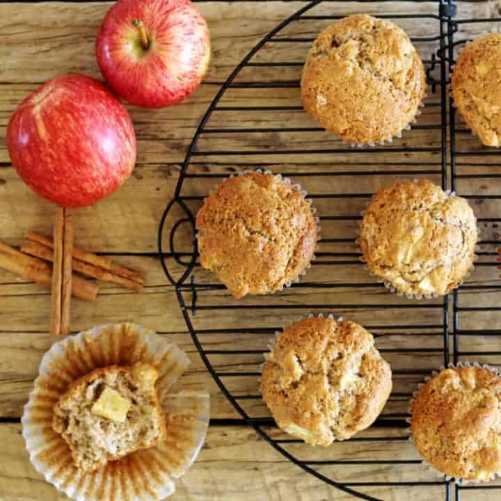 Spiced apple muffins on a wooden background with apples and cinnamon sticks