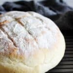 Cob loaf on a cooling rack with a blue tea towel