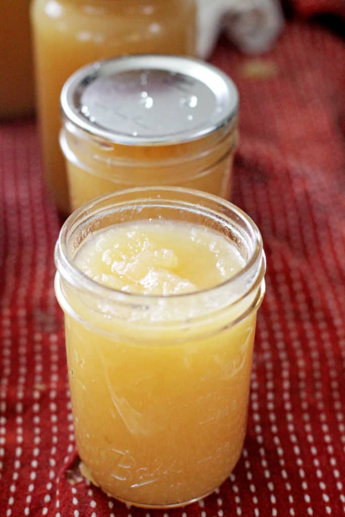 Open jar of applesauce ready to be canned