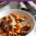 Fork in bowl of sausage pasta with text overlay