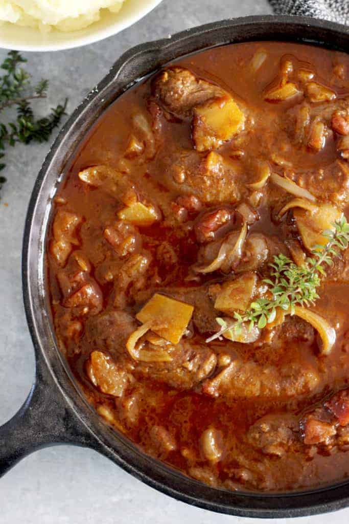 Pan of devilled sausages with mashed potato