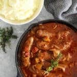 Pan of devilled sausages with mashed potato