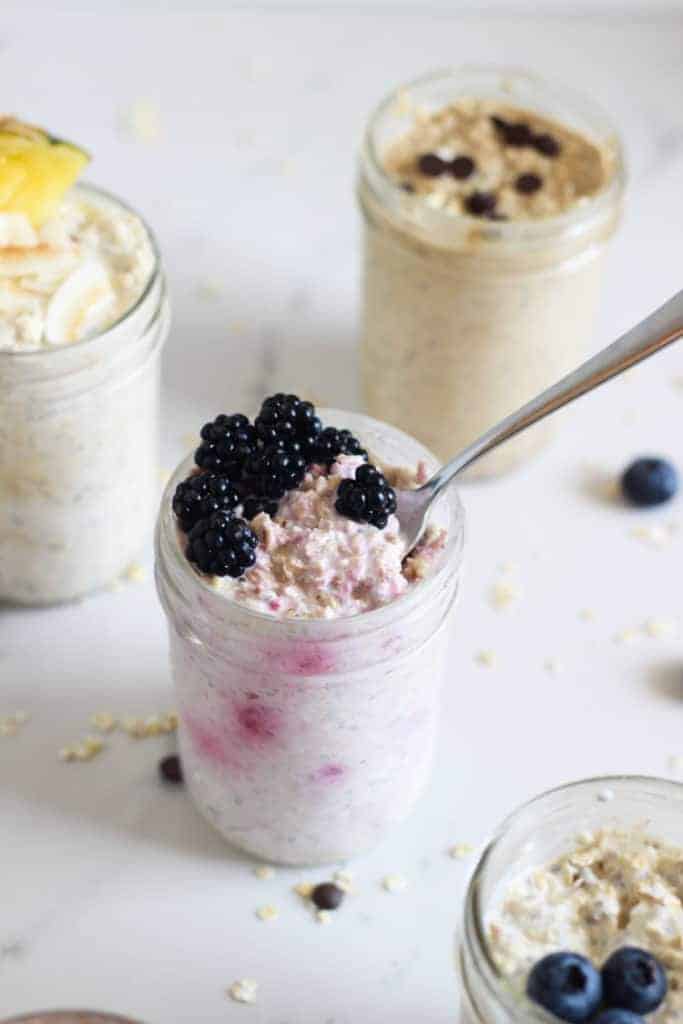 Jar of berry overnight oats with a spoon