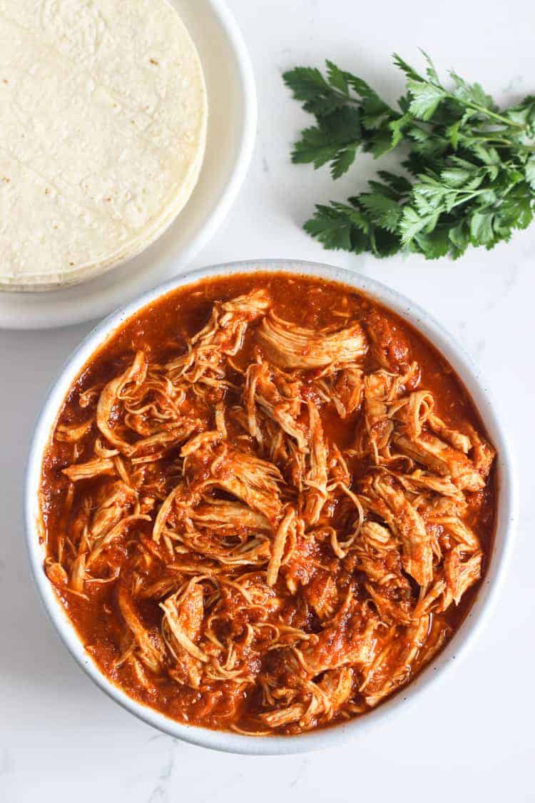 Shredded chipotle chicken in a bowl with tacos