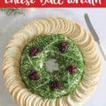 Christmas cheese ball wreath on serving plate with crackers and knife