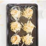 Oven tray with nests of homemade pasta with text overlay