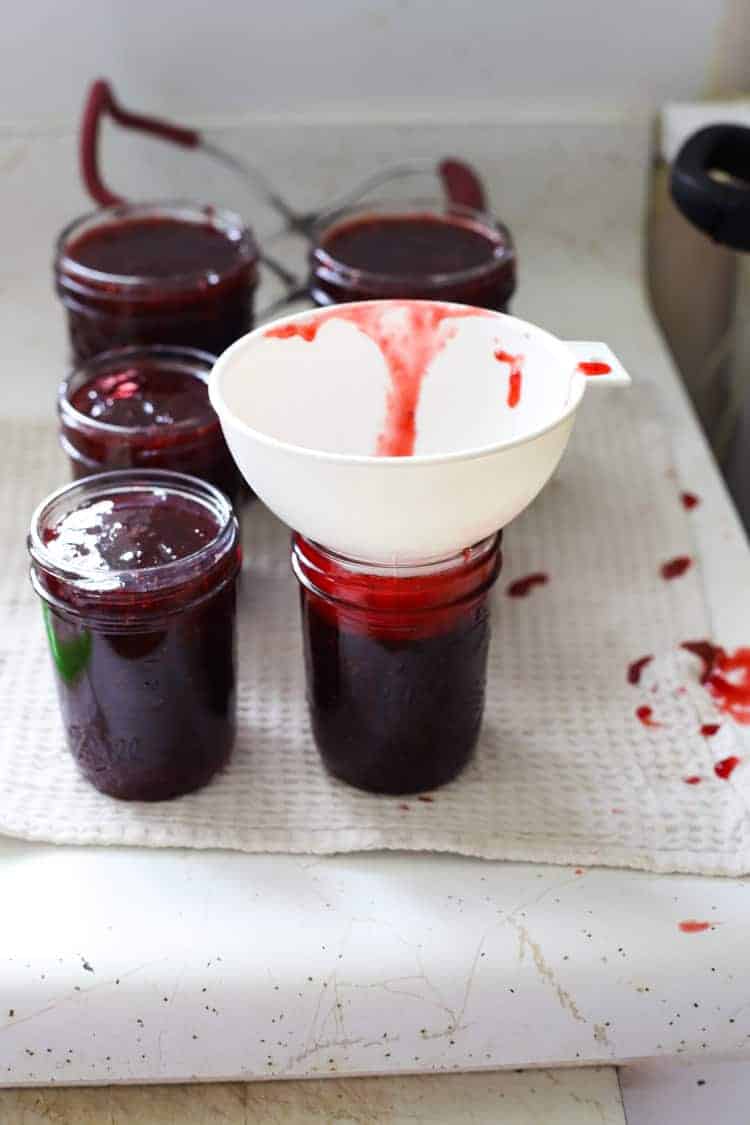 Jars of strawberry jam being filled