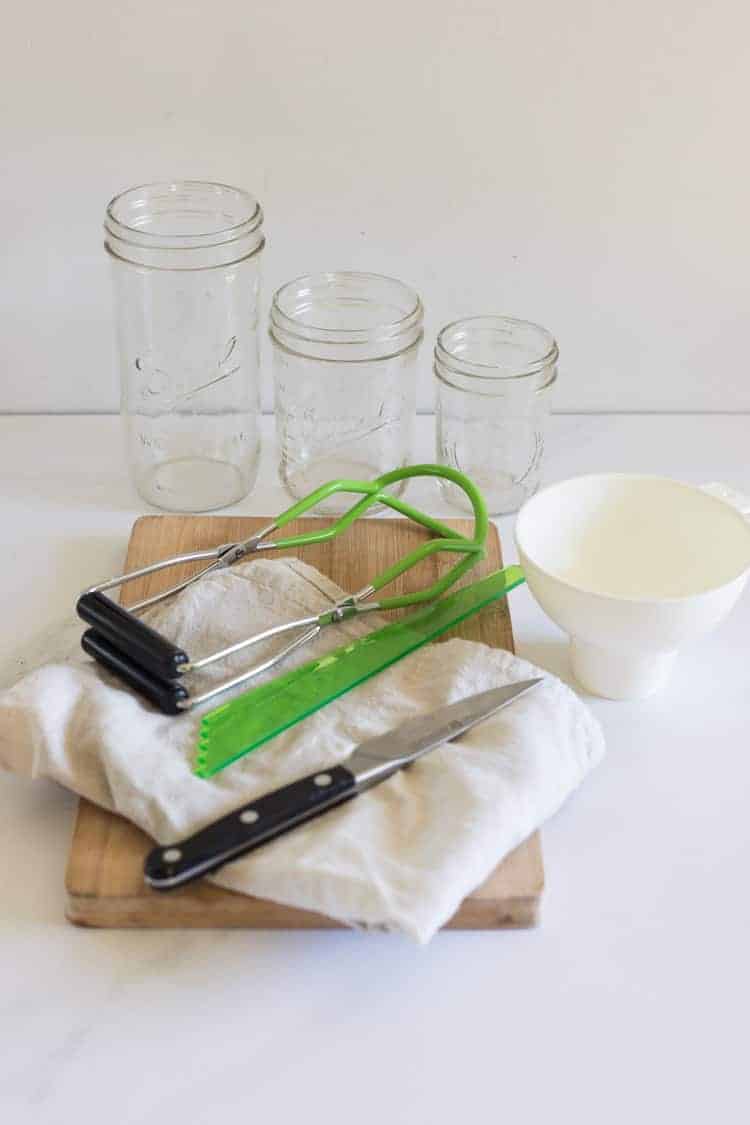 Preserving equipment - tongs, jars, funnel, tea towel, knife and chopping board