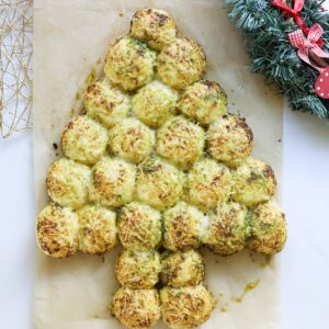 Pull apart bread in the shape of Christmas tree with wreath next to it