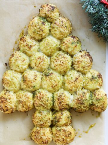 Pull apart bread in the shape of Christmas tree with wreath next to it