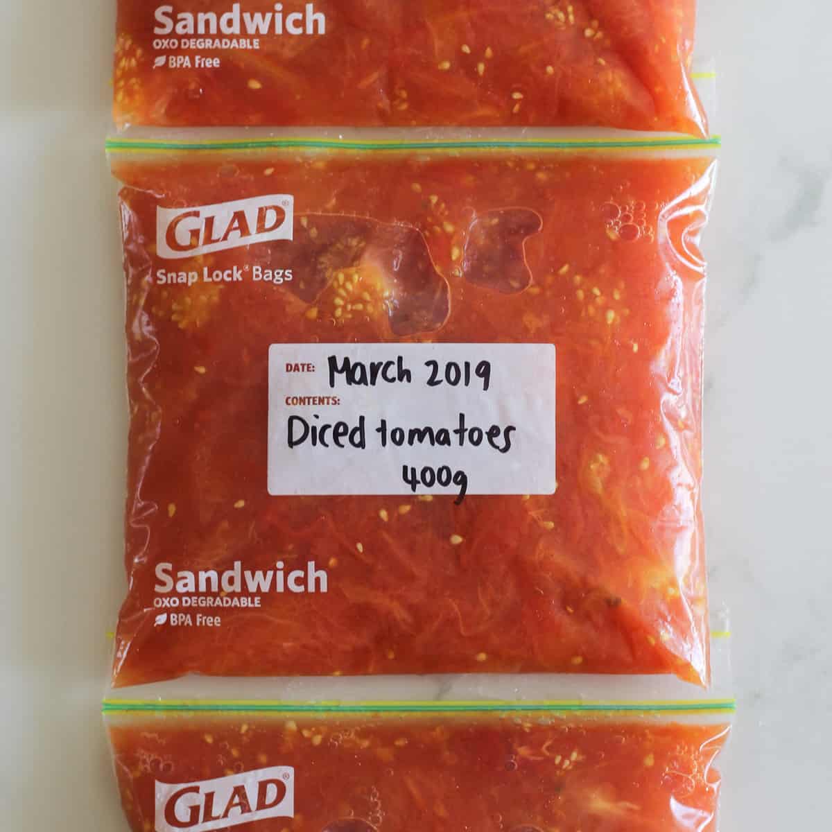 Snaplock bags with diced tomatoes ready to freeze