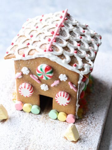 Decorated gingerbread house on board