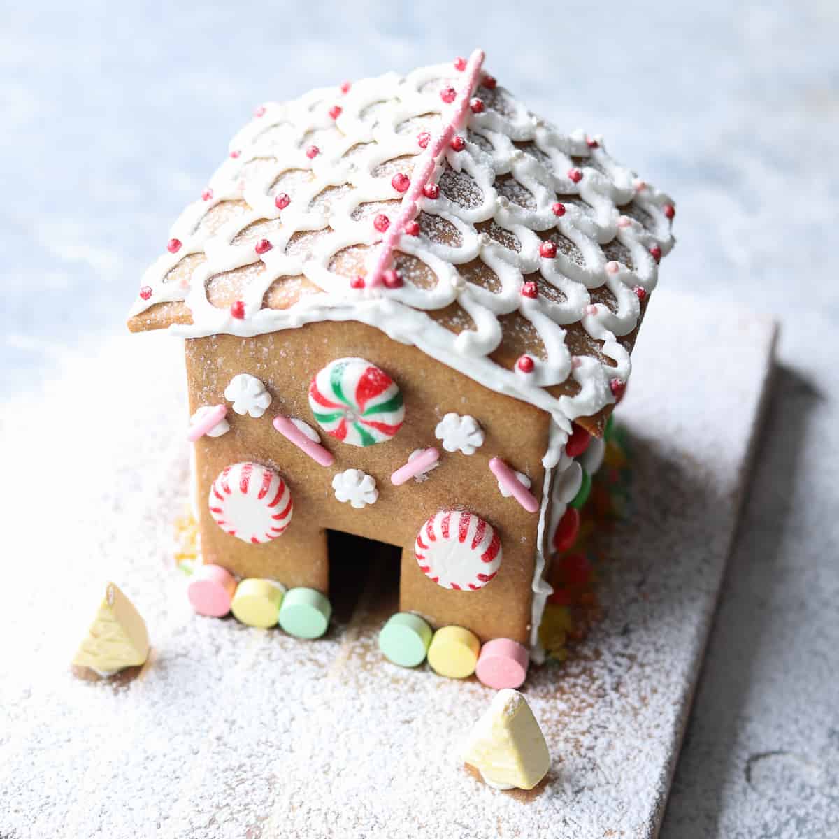Decorated gingerbread house on board